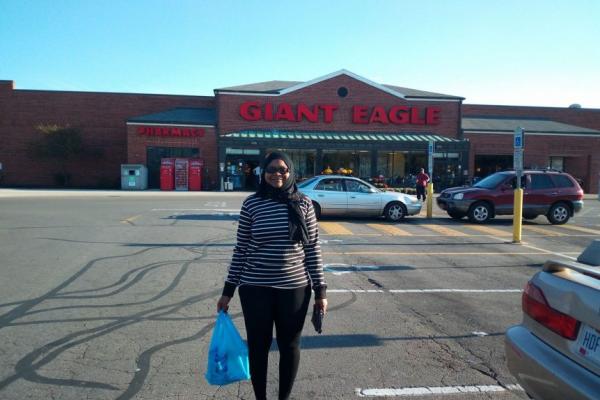 Zaina Hussein, a Black woman wearing a head scarf and sunglasses, standing in a Giant Eagle parking lot