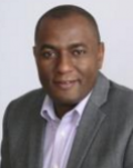 Marcel Yotebieng, a Black man with a shaved head, wearing business attire