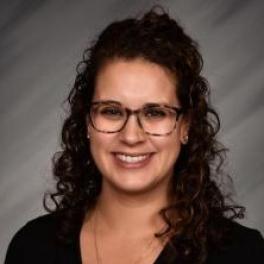 Mary Rodriguez, a latina woman with long, brown curly hair and glasses