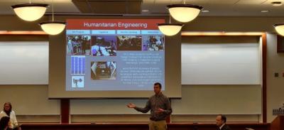 A man giving a presentation with a projector screen