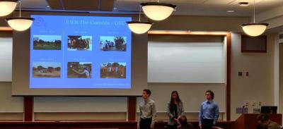 A group of three people giving a presentation using a projector screen