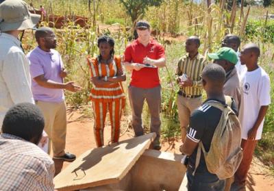 A ten-person group standing in a loose circle having a conversation