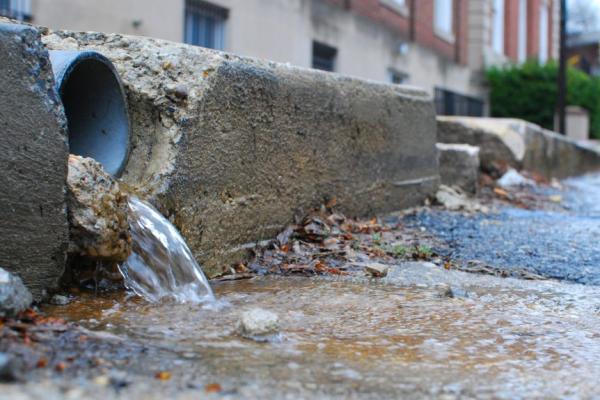 Ground level drain pipe spilling water into the street