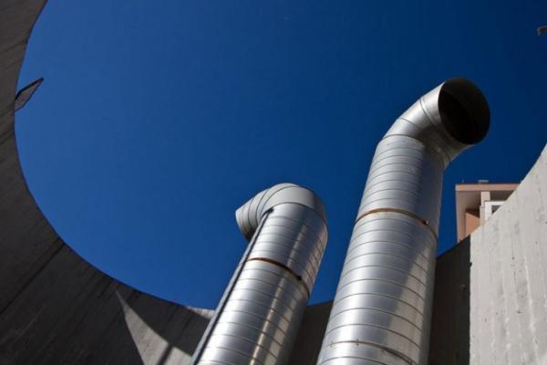 Large metal tubes sticking out from a massive, circular, metal chamber