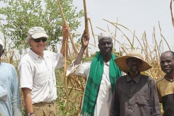 Four black men and one white man standing in a filed of yellow reeds