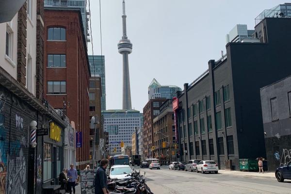 City street scene of Toronto with the tower in a distance.