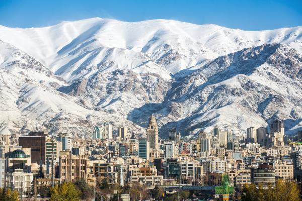 A city scape at the base with snow covered mountain in the back dropped,