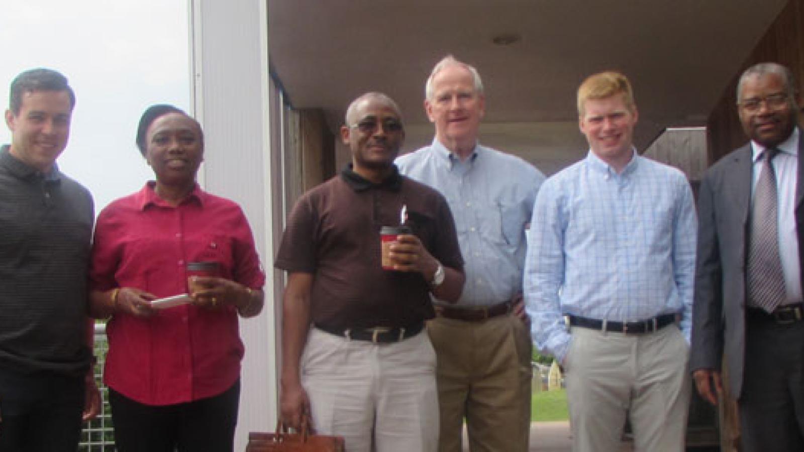 Mixed race, mixed gender group of people in business casual wear standing outside of a building